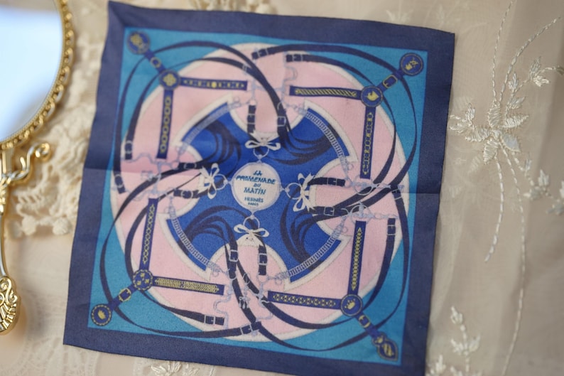 Blue and pink geometric 1/6 doll scarf laid flat beside a gold-framed mirror