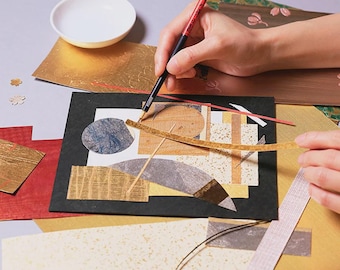 Könnte beinhalten: Ein Collage-Kunstprojekt mit verschiedenen strukturierten Papierformen in Gold, Schwarz, Grau und Beige, die auf einer schwarzen quadratischen Basis angeordnet sind. Ein dünner rot-schwarzer Pinsel wird über die Komposition gehalten, dazu Papierreste.