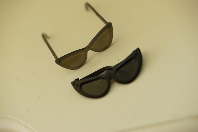 Foldable black and translucent black 1/6 doll sunglasses shown open and folded