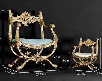 Könnte beinhalten: Zwei verzierte goldfarbene Stühle mit geschwungenen Rahmen und hellblau gemusterten Sitzflächen. Der größere Stuhl ist 30 cm hoch, 21,5 cm breit und 19,7 cm tief. Der kleinere Stuhl ist 17 cm hoch, 12,2 cm breit und 11,2 cm tief.