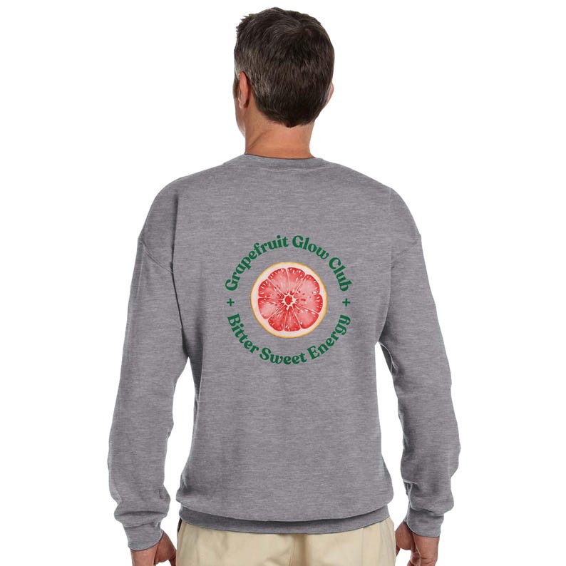May include: A heather gray sweatshirt with a circular graphic on the back. The graphic features a cross-section of a grapefruit with the words "Grapefruit Glow Club" and "Bitter Sweet Energy" in green text around the fruit.