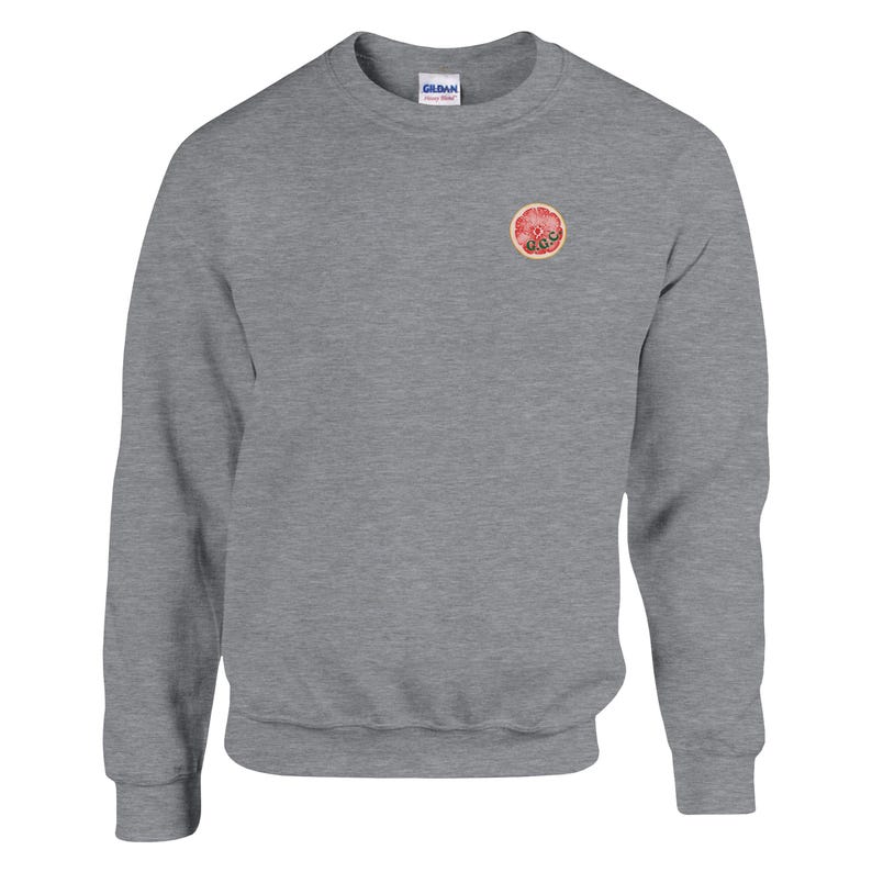 May include: A heather gray sweatshirt with a crew neck and long sleeves. A small, circular graphic of a grapefruit slice is on the upper left chest. The sweatshirt is made of a soft material.