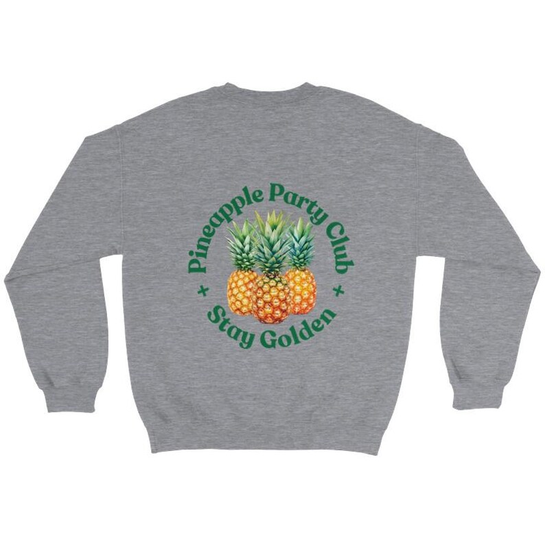 Puede incluir: Una sudadera gris jaspeado con un dise&ntilde;o circular que presenta tres pi&ntilde;as y el texto "Pineapple Party Club Stay Golden" en verde. Las pi&ntilde;as son amarillas y naranjas con copas verdes.