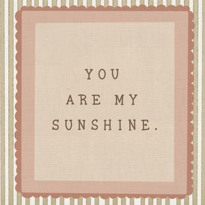 May include: A rectangular wall art piece featuring a beige and white vertical striped background. Centered is a dusty rose scalloped square frame containing the text YOU ARE MY SUNSHINE. in a dark brown, typewriter-style font on a light tan field.