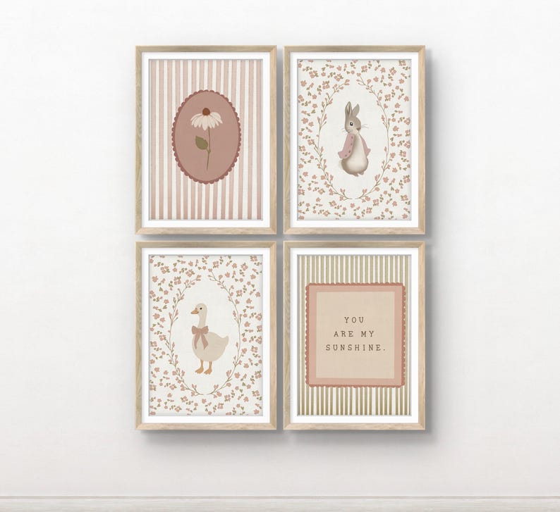 May include: A set of four framed wall art prints in light wood frames. The prints feature a daisy on a striped background, a rabbit in a floral wreath, a goose with a bow in a floral wreath, and the text YOU ARE MY SUNSHINE on a striped background.
