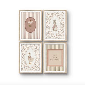 May include: A set of four framed wall art prints in light wood frames. The prints feature a daisy in a scalloped oval, a rabbit in a floral wreath, a goose with a bow in a floral wreath, and the text YOU ARE MY SUNSHINE in a scalloped square.