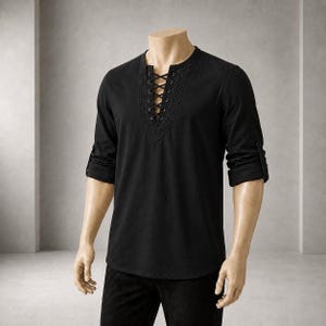 May include: A black long-sleeved shirt featuring a V-neckline with a lace-up closure. The neckline is framed by decorative eyelet trim and thin black laces. The sleeves are rolled up to the elbows, and the shirt has a straight hemline.