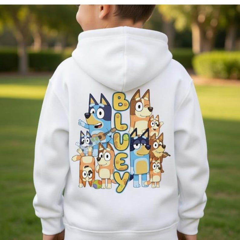 Puede incluir: Sudadera con capucha blanca con un gr&aacute;fico colorido de perros de dibujos animados y la palabra "Bluey". El dise&ntilde;o incluye personajes en azul, naranja y marr&oacute;n. La sudadera tiene una capucha con cord&oacute;n y un bolsillo canguro.