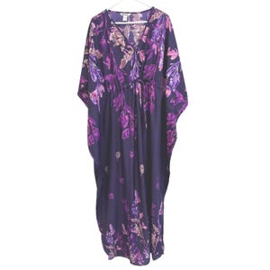 Könnte beinhalten: Ein bodenlanges Kaftan-Kleid in einem tiefen Violett mit einem lebendigen Blumenmuster in hellen Violett-, Magenta- und zarten Rosatönen. Das Kleidungsstück verfügt über einen V-Ausschnitt, weit fließende Ärmel und ein Taillenband zum Raffen.