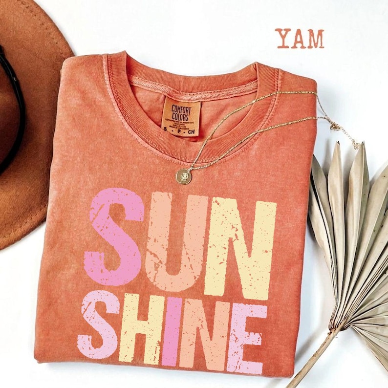 Coral comfort colors t-shirt with 'SUNSHINE' graphic in pink and yellow gradient, Comfort Colors tag
