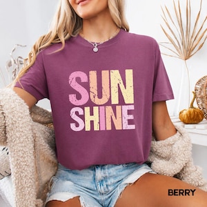 Berry t-shirt with 'SUNSHINE' graphic in pink, yellow, and orange lettering