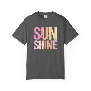 Dark gray t-shirt with 'SUNSHINE' graphic in distressed lettering, 'SUN' in pink and yellow, 'SHINE' in pink and orange