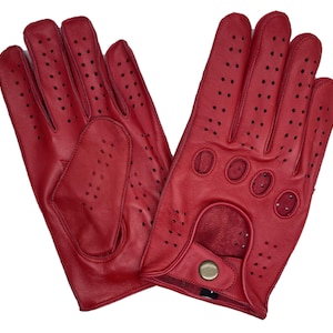 Könnte beinhalten: Ein Paar leuchtend rote Lederhandschuhe mit kleinen Perforationen für Atmungsaktivität. Die Handschuhe haben einen Druckknopfverschluss und sind für das Autofahren oder andere Aktivitäten konzipiert. Auf weißem Hintergrund.