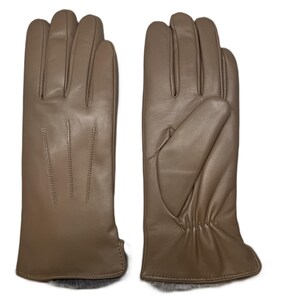 Op de afbeelding: Een paar taupekleurige leren handschoenen. De handschoenen worden getoond met de palm en de achterkant van de hand naar boven. De handschoenen hebben een zachte, soepele uitstraling en zijn waarschijnlijk ontworpen voor warmte en bescherming. De handschoenen hebben een bontrand aan de pols.