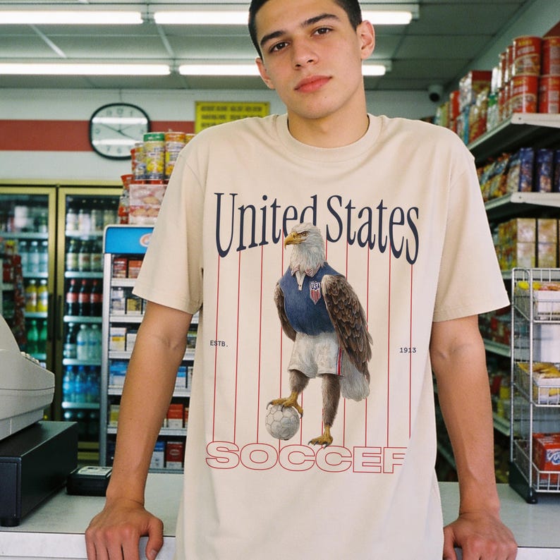 Vintage USMNT soccer fan graphic t-shirt with bald eagle soccer player on a washed navy comfort colors graphic tee of USA world cup soccer fans