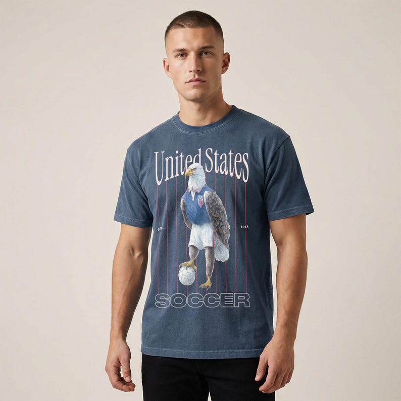 Vintage USMNT soccer fan graphic t-shirt with bald eagle soccer player on a washed navy comfort colors graphic tee of USA world cup soccer fans
