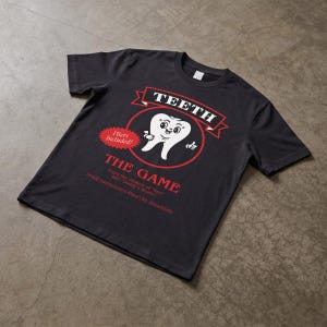May include: A black short-sleeve t-shirt featuring a graphic of a cartoon tooth inside a red circle. The text reads: TEETH THE GAME, Pliers Included!, From the makers of Run and Daddy's Home, Proudly manufactured in Widow's Bay, Massachusetts.