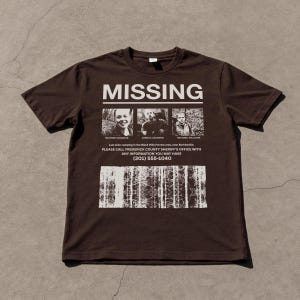 May include: A brown t-shirt with the word "MISSING" in white block letters. Below are three small black and white photos of people. Underneath the photos is text that reads "PLEASE CALL FREDERICK COUNTY SHERIFF'S OFFICE WITH ANY INFORMATION YOU MAY HAVE (301) 555-1040."