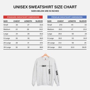 May include: A unisex sweatshirt size chart with measurements in inches. The chart details standard and premium sweatshirt sizes, including chest, length, and sleeve dimensions for sizes small to 3X-Large. A grey sweatshirt is shown below the chart.