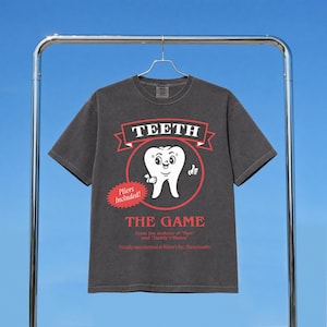 Funny Widow's Bay tv show t-shirt with Teeth board game graphic on a unisex washed black comfort colors graphic tee