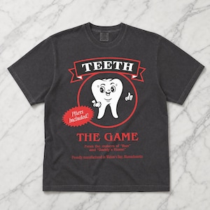 Funny Widow's Bay tv show t-shirt with Teeth board game graphic on a unisex washed black comfort colors graphic tee