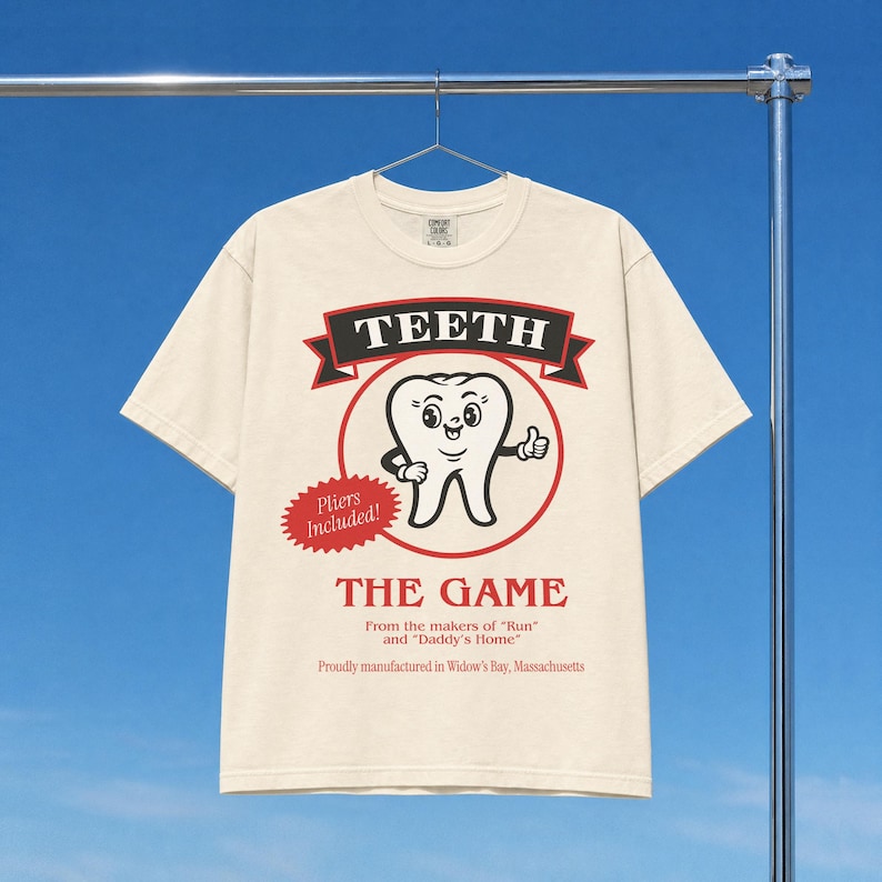 Funny Widow's Bay tv show t-shirt with Teeth board game graphic on a unisex washed cream off white comfort colors graphic tee