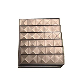 May include: A stack of rectangular, textured panels with a repeating diamond pattern. The panels have a metallic sheen and are framed with a dark border. The design creates a geometric and dimensional effect.