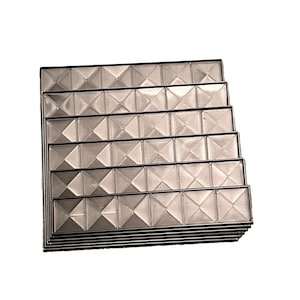 May include: A stack of clear, rectangular trays with a geometric, diamond-like pattern. Each tray is outlined with a thin, black border. The trays are stacked on top of each other, creating a tiered effect. The overall color is a neutral, translucent gray.