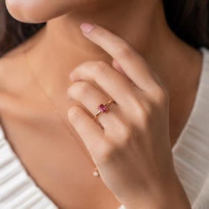 Delicate pink ruby gemstone 925 sterling silver gold plated ring worn on a model’s finger, showing the minimalist solitaire design and dainty band.