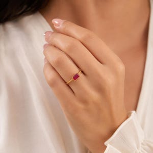 925 Sterling Silver Gold Plated Delicate ruby ring with horizontal gemstone and twisted gold band worn on a model’s finger.