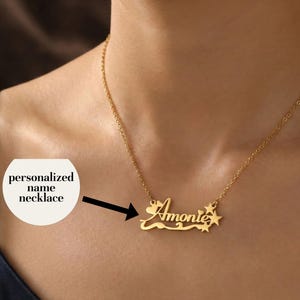 May include: A gold-colored personalized name necklace with the name "Amonte" in a cursive font. The necklace features a delicate chain and star-shaped embellishments. The text "personalized name necklace" is in a white circle.