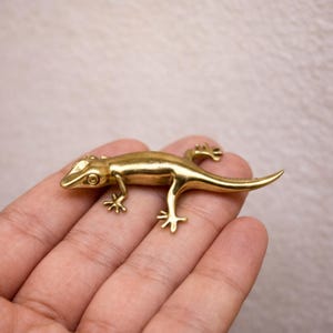 Könnte beinhalten: Set aus drei Keramikbechern mit gesprenkelter, matter Oberfläche. Die Becher sind in Creme-, Hellgrau- und Dunkelgrautönen gehalten. Jede Tasse hat ein schlichtes, minimalistisches Design.