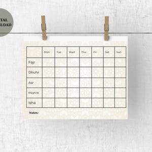 May include: A beige digital download printable calendar with a decorative pattern, held by two wooden clips. The calendar grid is for daily tracking of Fajr, Dhuhr, Asr, Maghrib, and Isha prayers, with space for notes. The words "DIGITAL DOWNLOAD" are in a circle.