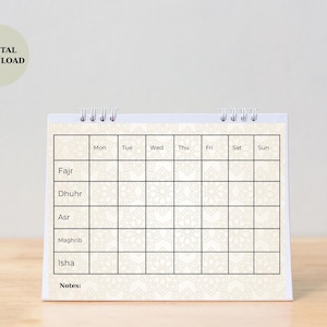May include: A spiral-bound desk calendar with a cream-colored background and a geometric pattern. The calendar grid is divided into days of the week, with spaces for prayer times: Fajr, Dhuhr, Asr, Maghrib, and Isha. The words "DIGITAL DOWNLOAD" are in a circle.