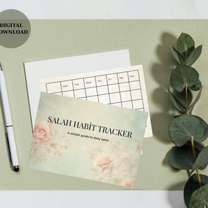 May include: A digital download featuring a "Salah Habit Tracker" card with floral accents, a calendar, and a white pen. The card has the text "Salah Habit Tracker" and "A simple guide to daily salah". The background is a light green color.