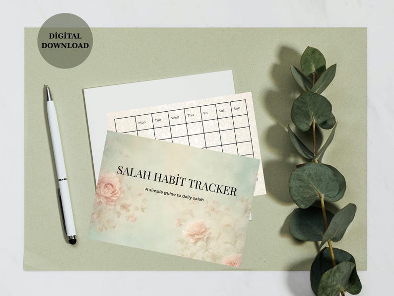 May include: A digital download featuring a "Salah Habit Tracker" card with floral accents, a calendar, and a white pen. The card has the text "Salah Habit Tracker" and "A simple guide to daily salah". The background is a light green color.