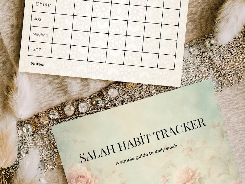 May include: Two printed sheets with a floral design and the text "SALAH HABIT TRACKER" and "A simple guide to daily salah". The top sheet has a grid for tracking daily activities.