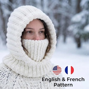 May include: A person wearing a cream-coloured knitted hood and cowl in a snowy environment. The hood and cowl are thick and textured, with a ribbed design around the neck and lower face. Text reads "English & French Pattern".