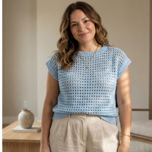 Puede incluir: Un top de crochet azul claro con cuello redondo y mangas cortas. El top tiene un tejido abierto y aireado. La modelo lleva un collar y una pulsera dorados. El top se combina con pantalones beige.