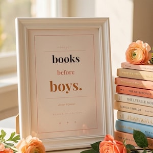 Peut inclure: Un cadre photo rectangulaire blanc contenant une impression avec le texte books before boys. L'impression inclut les phrases always & forever et READER COLLECTION. Le cadre est entouré de fleurs couleur pêche et d'une petite clé dorée.