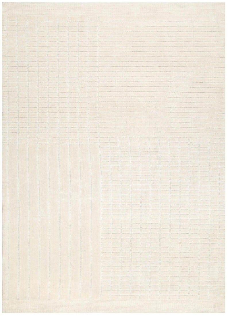 Pu&ograve; includere: Tappeto rettangolare color crema con motivo strutturato. Il design presenta una combinazione di linee orizzontali e verticali, creando un aspetto a griglia. Il colore neutro del tappeto lo rende adatto a vari stili di interni.