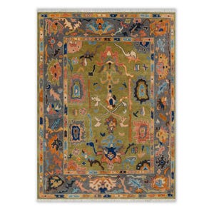 Peut inclure: Tapis rectangulaire avec un champ central vert olive et une bordure grise. Le tapis présente des motifs floraux et géométriques complexes dans des tons orange, rose, bleu et marine. Le tapis a une frange sur les petits côtés.