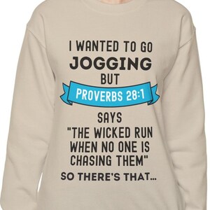 May include: A tan sweatshirt with a blue ribbon and black text that reads "I wanted to go jogging but Proverbs 28:1 says "The wicked run when no one is chasing them" So there's that..."