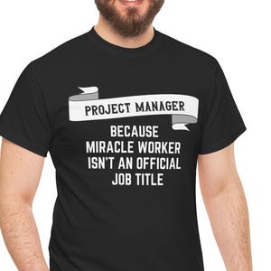 May include: Black t-shirt with white text that reads "Project Manager because miracle worker isn't an official job title".