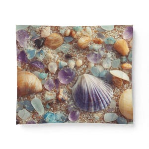 May include: A close-up of a sandy surface with seashells, sea glass, and gemstones. The seashells are tan and white, while the sea glass is blue and clear. The gemstones are purple and pink. The overall effect is a colorful and textured display.