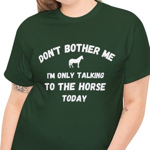 May include: A green t-shirt with white text that reads "Don't bother me I'm only talking to the horse today". A white silhouette of a horse is above the text.