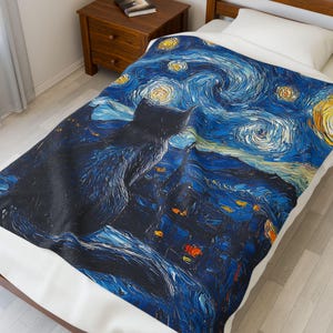May include: A black cat silhouette against a blue and yellow starry night sky, reminiscent of Vincent van Gogh's 'Starry Night'. The blanket features a swirling, brushstroke design.