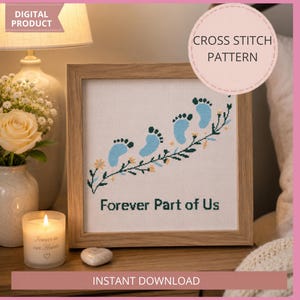 Może przedstawiać: Oprawiony wzór haftu krzyżykowego z niebieskimi odciskami stóp dziecka i napisem "Forever Part of Us". Projekt zawiera kwiatowe akcenty. Obraz jest produktem cyfrowym, z świecą i kwiatami w tle.