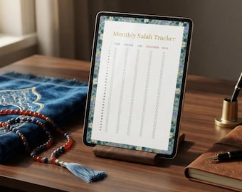 Peut inclure: Une tablette sur un support en bois affiche un Monthly Salah Tracker avec des colonnes pour Fajr, Dhuhr, Asr, Maghrib et Isha. L'écran présente une bordure florale. À proximité se trouvent un tapis de prière bleu, un chapelet et un carnet en cuir marron.