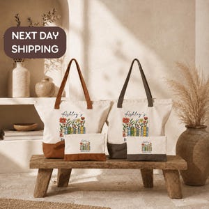 a set of four tote bags with floral designs, placed on a wooden bench. The bags are white with brown handles and appear to be made of canvas material. The bags are arranged in a row, with two on the left and two on the right. The background includes a shelf with decorative items, such as vases and a potted plant, creating a cozy and homely atmosphere.